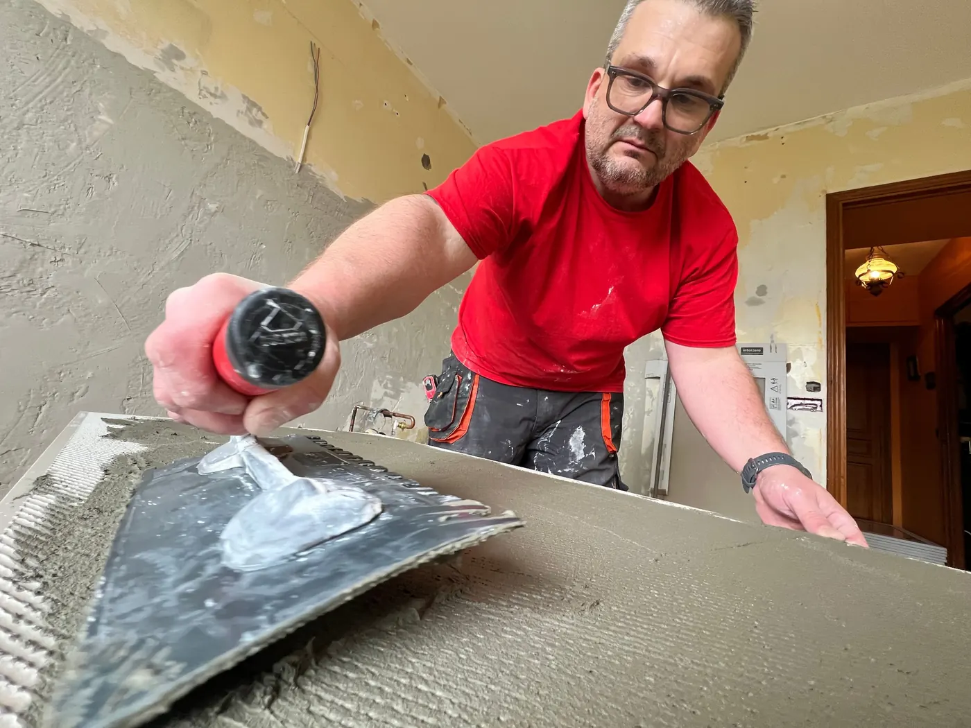 Artisan carreleur en cours de pose de carrelage