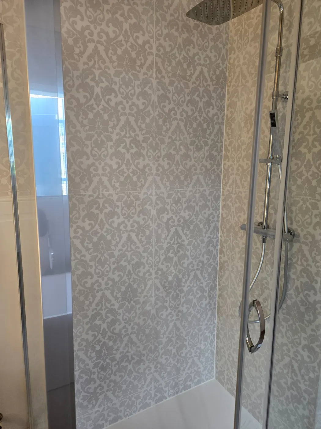 Douche avec habillage mural décoratif et finitions carrelées