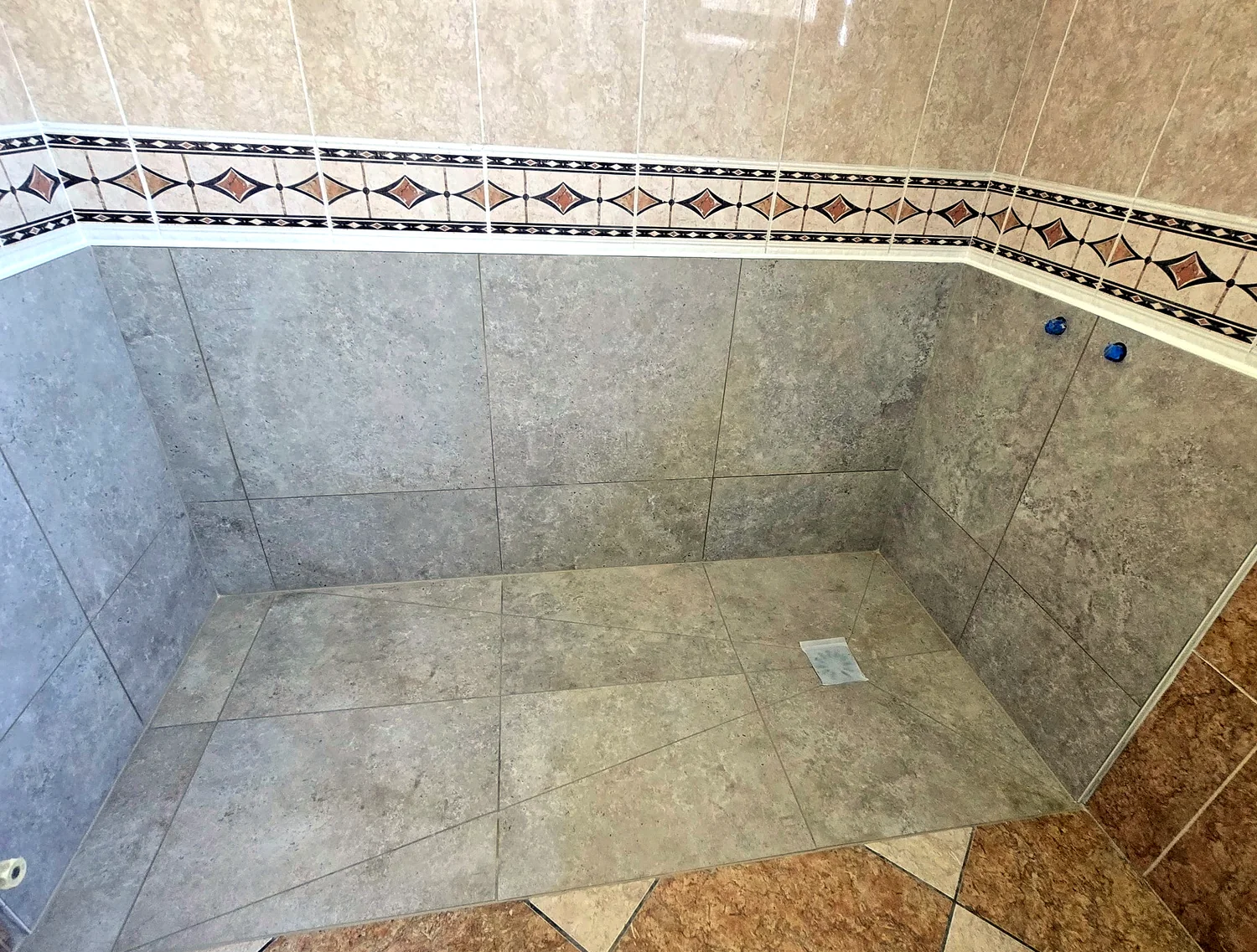 Douche à l'italienne carrelée avec receveur noir et finitions contemporaines